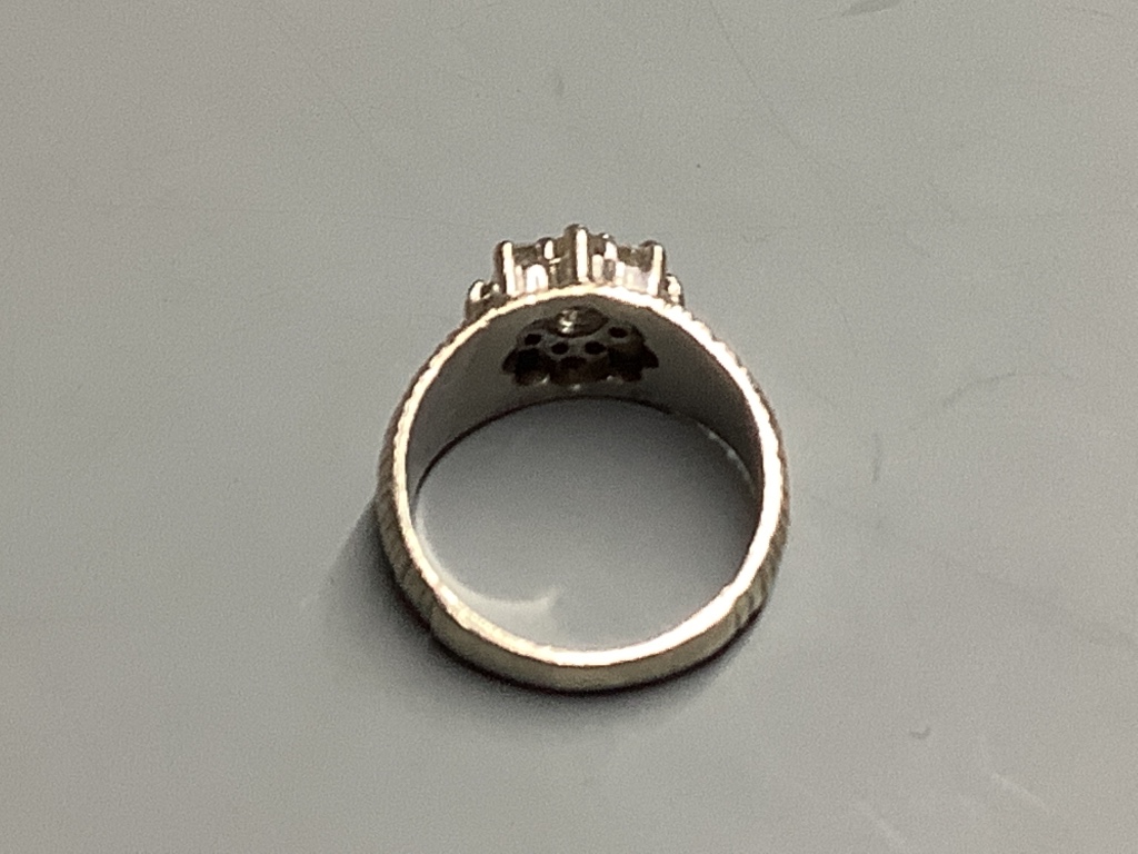 A modern textured white metal and diamond cluster set dress ring